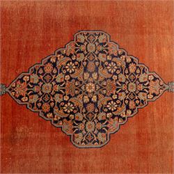 North West Persian Tabriz hand-knotted carpet, salmon field with central elongated lozenge medallion intricately filled with scrolling arabesques and palmettes, framed by stylized corner spandrels within a broad indigo main border  of bold palmettes and floral vinery between multiple guard stripes, rendered in tones of terracotta, sage green, and soft ivory, with cotton fringe ends 