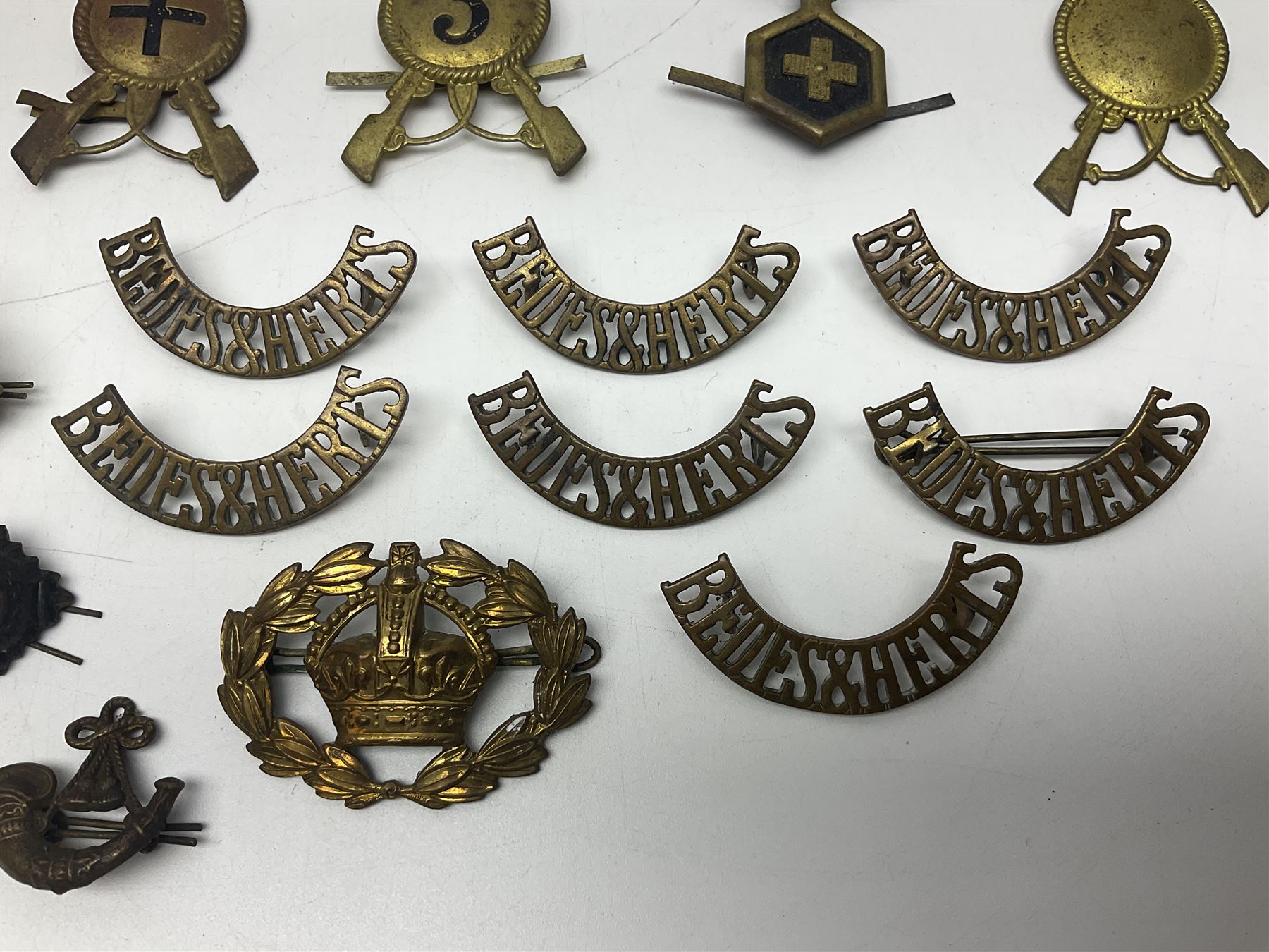 Over thirty British and Continental military metal badges; together with quantity of shoulder titles, collar dogs, rank pips, uniform buttons etc