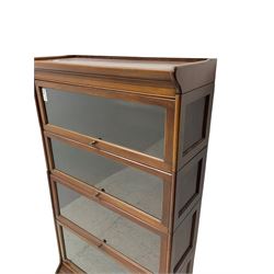 Early 20th century mahogany stacking library bookcase, four-tiers enclosed by hinged and sliding glazed doors, on moulded plinth base