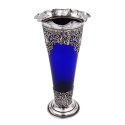 Victorian silver mounted blue glass trumpet vase, the silver mounts with pierced and embossed floral, C scroll and lattice decoration, with frilled rim, upon stepped circular foot, hallmarked Henry Matthews, Birmingham 1899