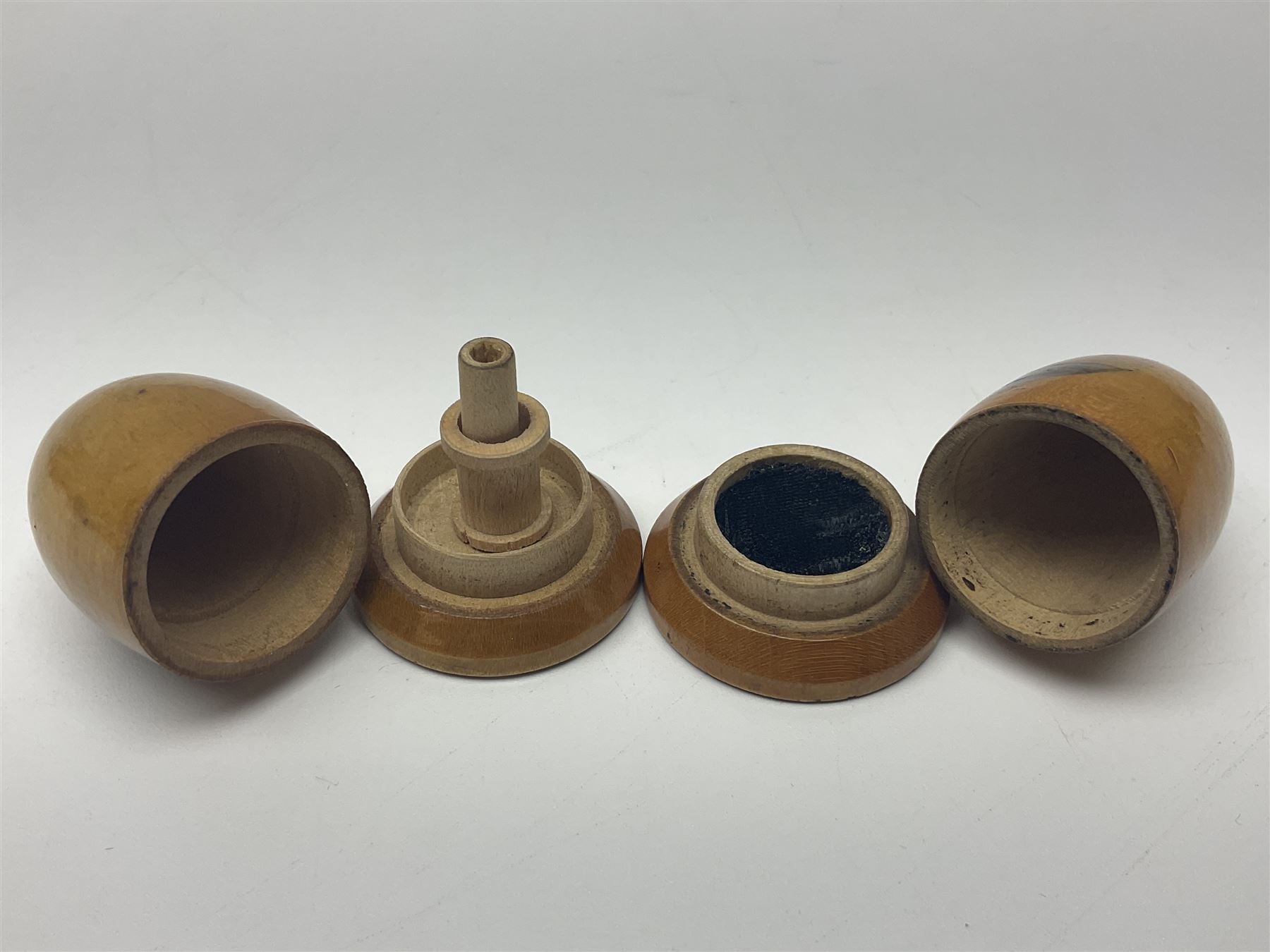 Six sewing related Mauchline ware comprising an oval reel box with internal label for Clark & Co's, tape measure, pin case and three thimble holders of ovoid form 