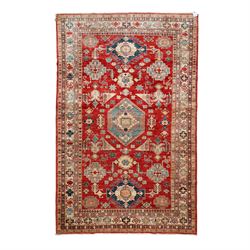 Caucasian design hand-knotted wool rug, red ground with central medallion in ivory and ind...
