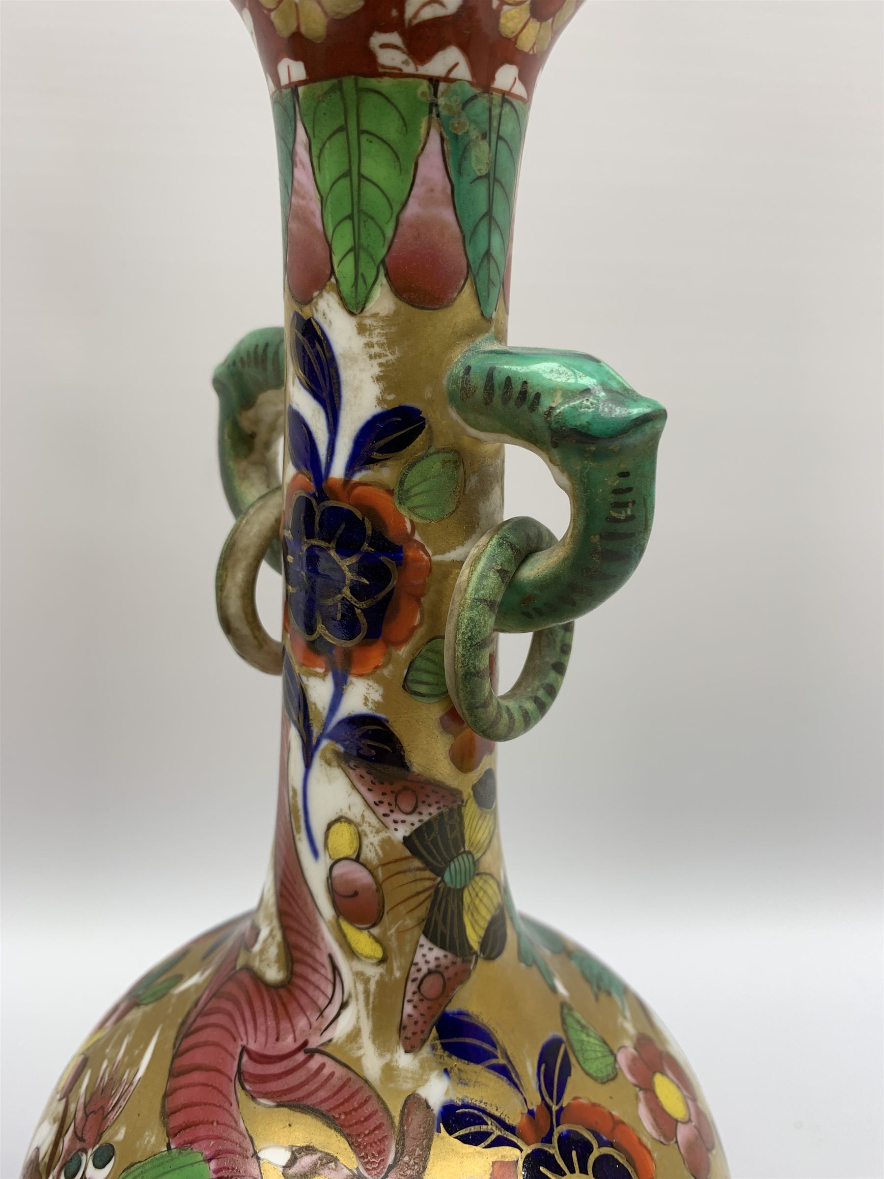 Pair of early 19th century Miles Mason vases, the baluster bodies with tall slender necks supporting twin stylised trunk handles with rings, decorated with Chinese dragons, butterflies, and blossoming flowers against a gilt ground, with spurious Chinese marks beneath in iron red, H27.5cm