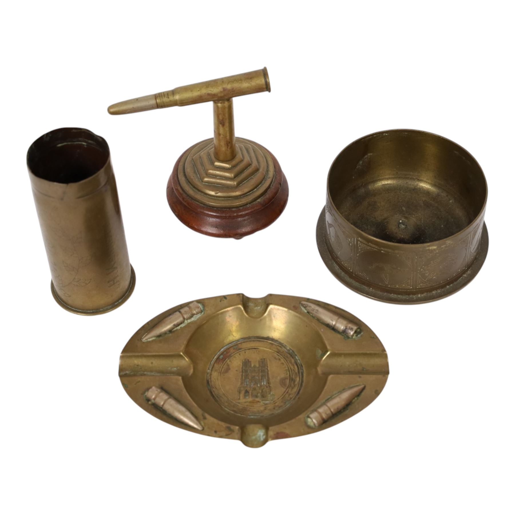 Collection of trench art, including a vase with scalloped rim, applied with a helmet plate to the 45th regiment, mounted on a canted rectangular walnut plinth, together with ashtray with matchbox holder to the center, pair of Boer war vases etc 