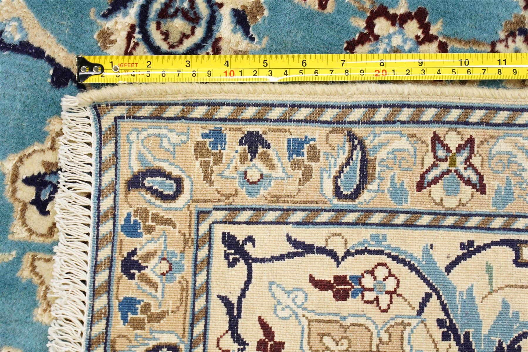 Central Persian Nain hand-knotted carpet, soft sky blue ground with central cusped medallion of radiating palmette form, issuing scrolling vine work, arabesques, and delicate floral sprays, spandrels of conforming design, main border of ivory ground decorated with scrolling vine work palmettes and stylized floral motifs, flanked by narrow guard stripes, with cotton fringe ends 