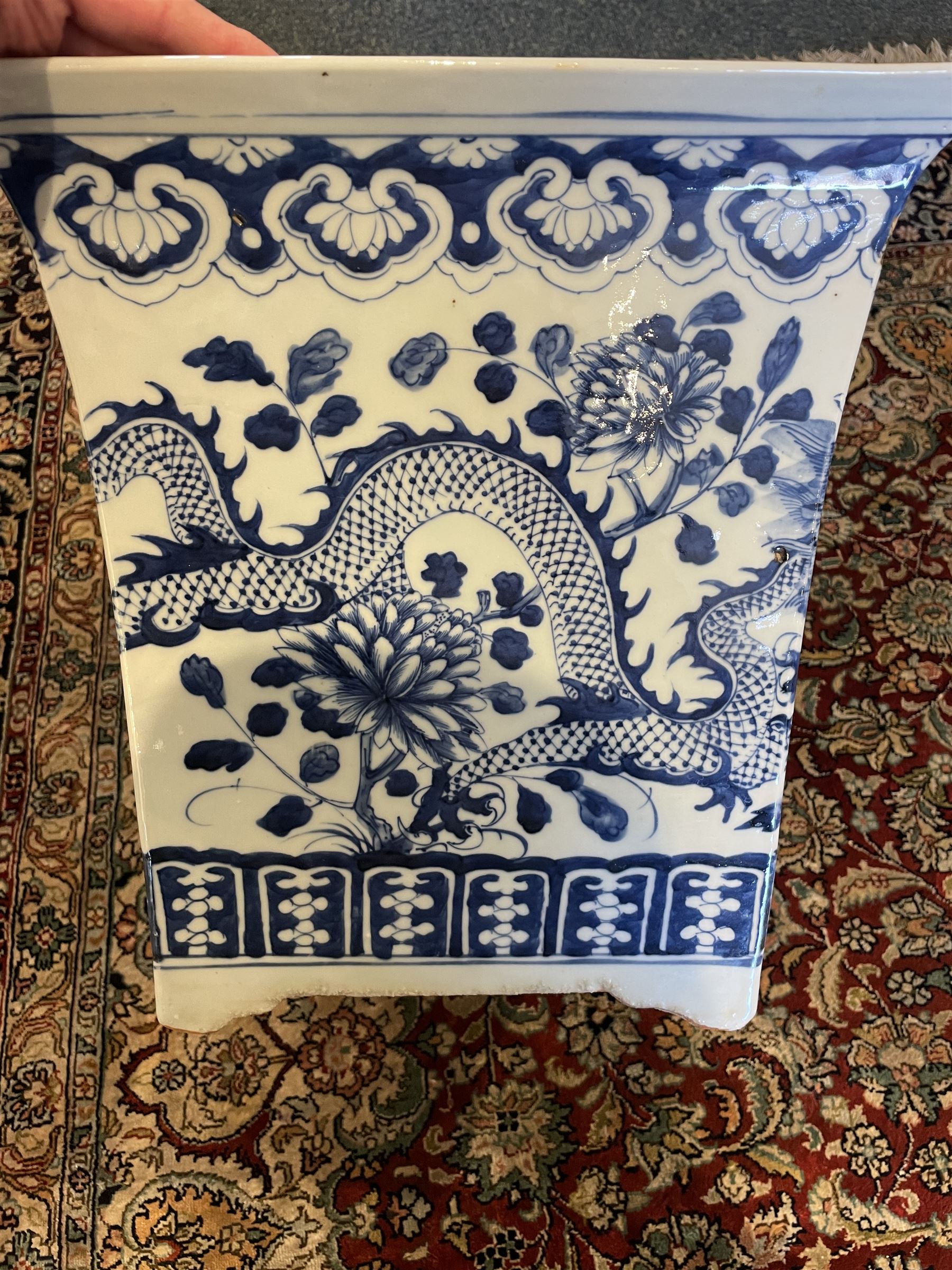 Chinese blue and white planter and stand, each of square slightly tapering and flared form, the planter decorated with two dragons and blossoming peonies, between stylised borders, the stand decorated with flower heads and vines, planter H30cm W29cm, stand H7cm D28.5cm