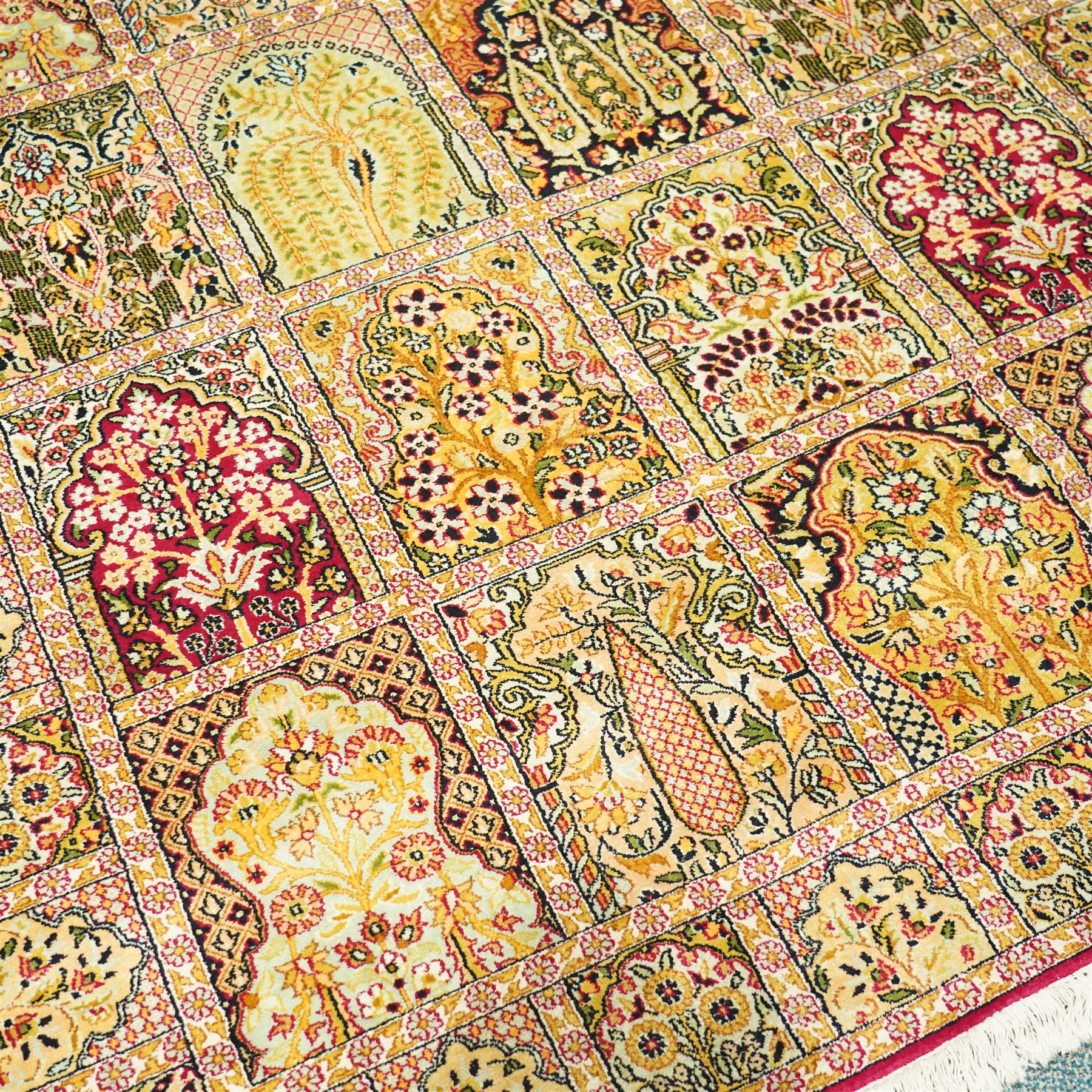 Late 20th-century Persian panel design silk and cotton blend rug, in pale tones of ivory, pistachio, green, crimson, pale blue, and rose, each compartment enclosing a stylized mihrab, boteh, cypress, and floral motifs, framed by a narrow floral border with guard stripes and cotton fringe ends 