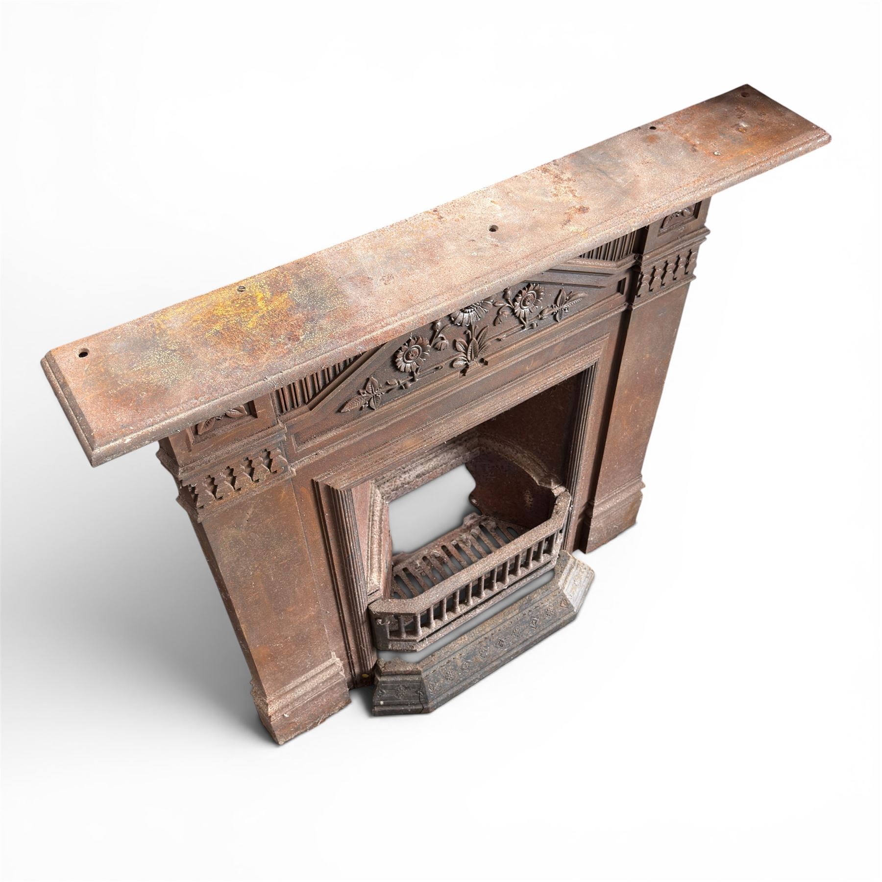 Late Victorian cast ion bedroom fireplace, decorated with floral poppy motifs and flluting