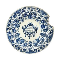 Early 18th century Delft marriage plate, of circular form with dished centre, the centre inscribed and dated 'Thomas and Elizabeth Kockerill Bridlington Key 1715' within a crowned C scroll cartouche, flanked by demi-griffins, above a putto head and tassels, within a wide foliate border, D34cm
