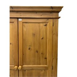 Solid pine double wardrobe, projecting moulded cornice over two panelled doors, on skirted base