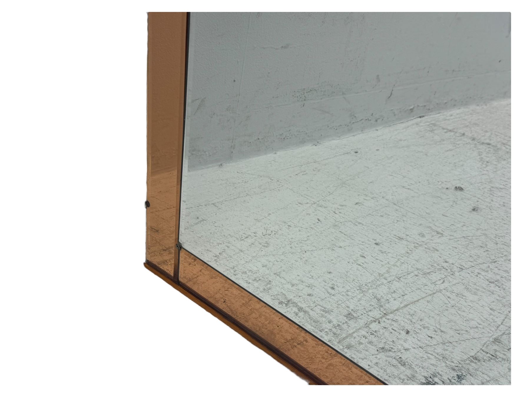 Frameless art deco mirror, scalloped copper tinted border central fan motif, bevelled edges with decorative screw caps