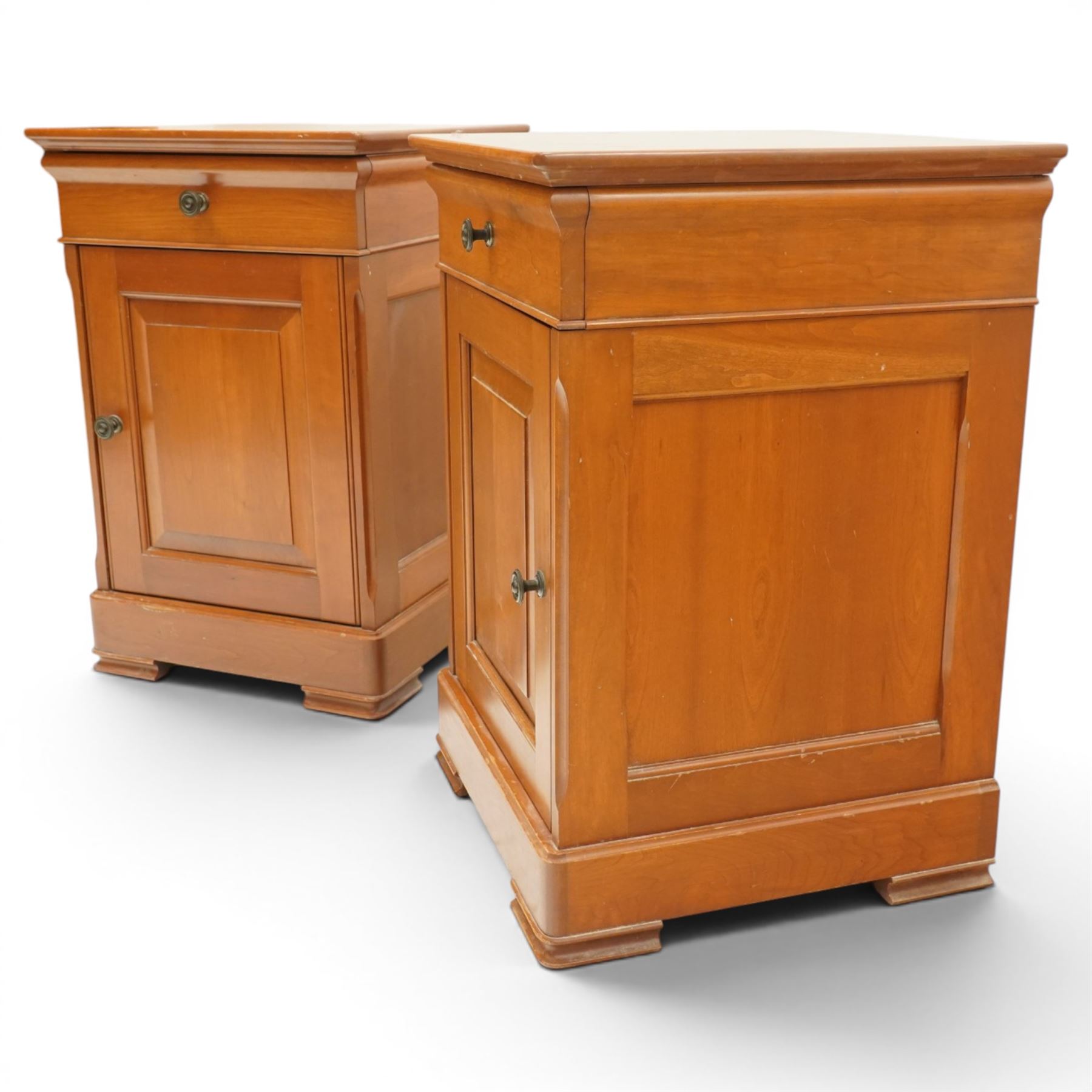 St Michael - pair of cherrywood bedside tables, single drawer above a fielded panel door, brass pulls, raised on a plinth base