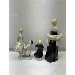Mid-century Polonne figure group depicting a young girl at a dress fitting, with printed blue mark beneath, together with another USSR figure of a seated young girl in black dress, stamped beneath, and further figure of a lady in black dress and shawl, with impressed 435 and printed marks beneath, H28cm