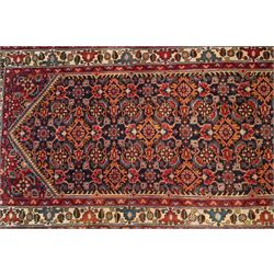 North-west Persian Malayer runner rug, the indigo ground decorated with ivory medallions and an all-over Herati pattern, red floral spandrels, enclosed by an ivory trailing floral border and crimson patterned guard stripes