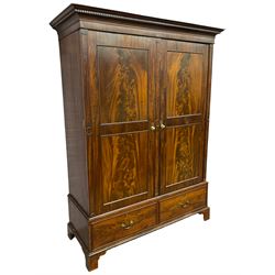 George III mahogany double wardrobe, the projecting cornice with dentil moulding over two panelled doors with mirror-lined interiors, enclosing hanging rails and brass hooks, the base fitted with two drawers, raised on bracket feet