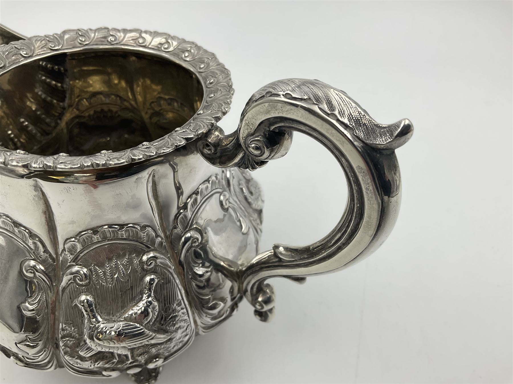 Victorian silver three piece tea service, comprising teapot, twin handled open sucrier, and milk jug, each of bellied form with acanthus capped scroll handles, the sides embossed with alternating scroll edged vacant panels and panels containing a pair of birds, upon four palmette feet, the teapot with ivory insulators to handle, and bird finial to the hinged domed cover, hallmarked William Hunter & Son, London 1861, teapot H19cm, including handles sucrier H13.5cm, including handle milk jug H12cm

This item has been registered for sale under Section 10 of the APHA Ivory Act