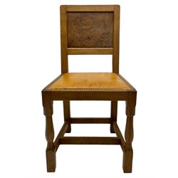 Eagleman - pair oak dining chairs, figured burr panelled backs over tan leather upholstered seats with stud band, the seat rail carved with eagle signature, on octagonal front supports joined by plain stretchers, by Albert Jeffray of Sessay, Thirsk