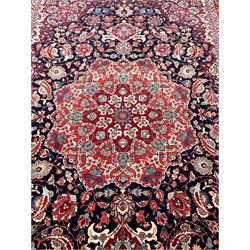 Persian Hamadan indigo ground rug, central floral crimson pole medallion surrounded by trailing foliate decoration and stylised plant motifs, the main guarded border with repeating stylised flower heads, densely knotted