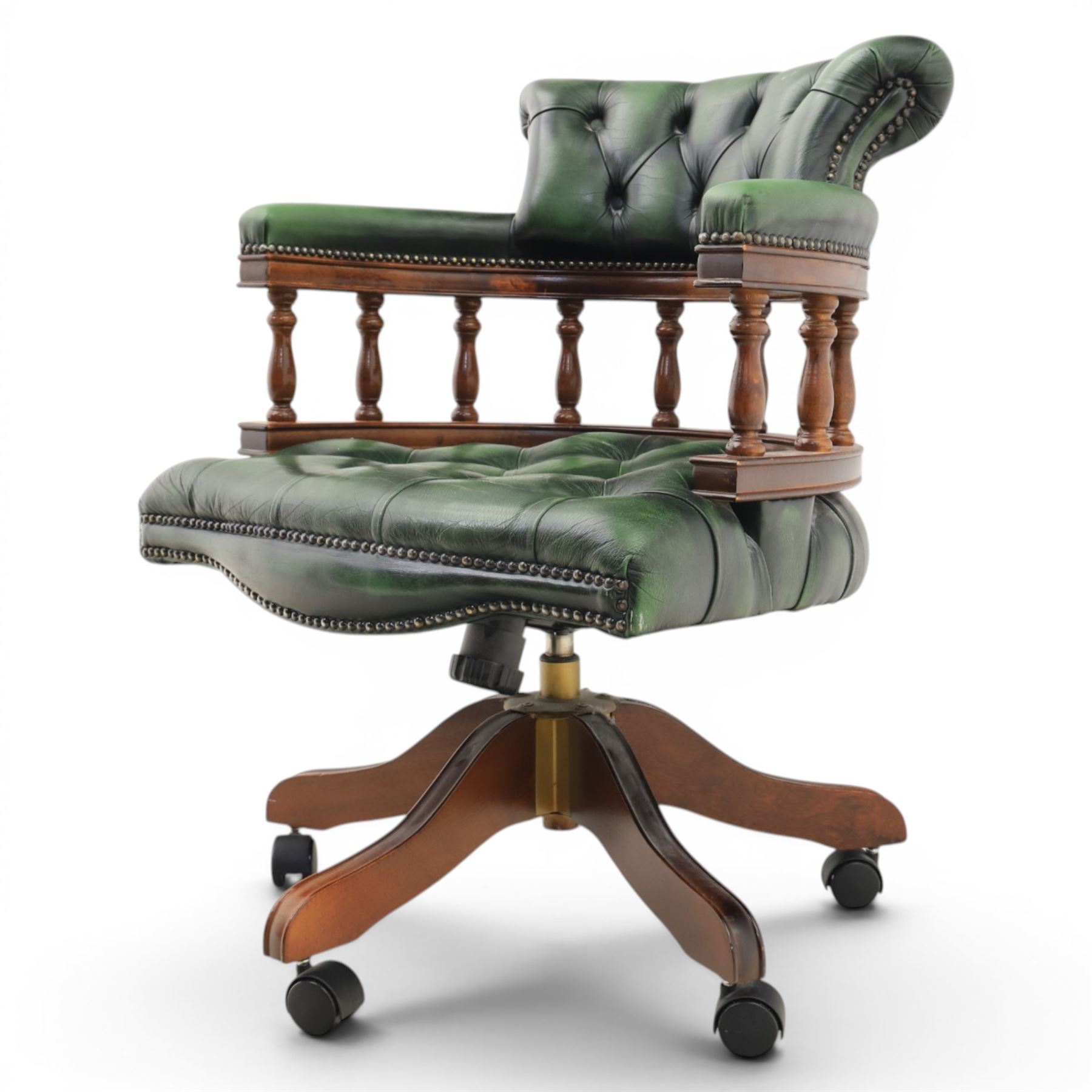 Captains swivel desk chair upholstered in buttoned green leather, five point star base raised on castors