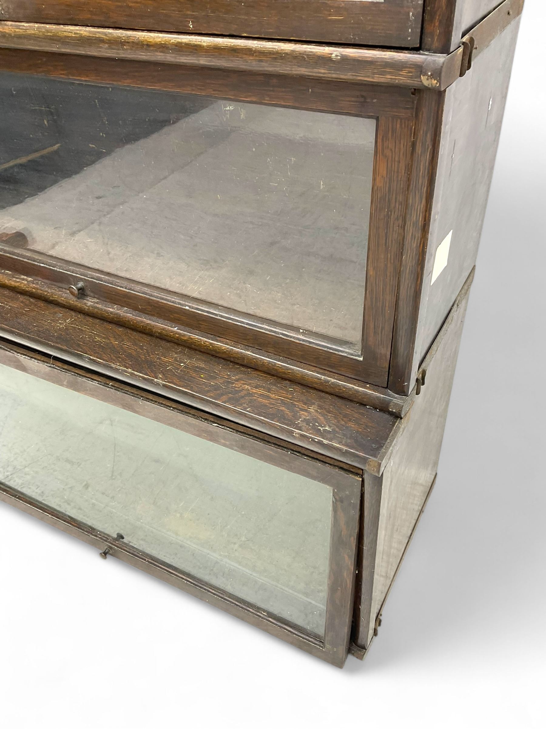 Globe Wernicke - early 20th century oak four-tier stacking library bookcase, four glazed sections enclosed by hinged and sliding doors