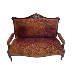 Late 19th century walnut framed settee, the shaped cresting rail with carved and pierced cartouche pediment, leaf carved ears, upholstered in scrolling foliate patterned fabric, acanthus carved arm supports, on cabriole supports with castors