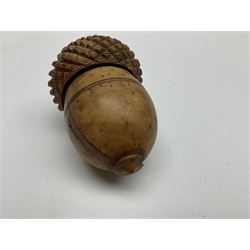 19th century coquilla nut nutmeg grater, modelled as an acorn, with screw threaded cover lifting to reveal a bone collar and steel grater, H7.5cm, together with a 19th century coquilla nut pomander or flea catcher, modelled as a pear and formed of two sections with screw threaded join, H6cm