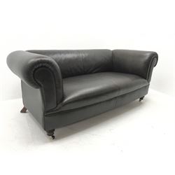 Three seat chesterfield style sofa, scrolling arms, turned supports on castors, upholstered in brown leather