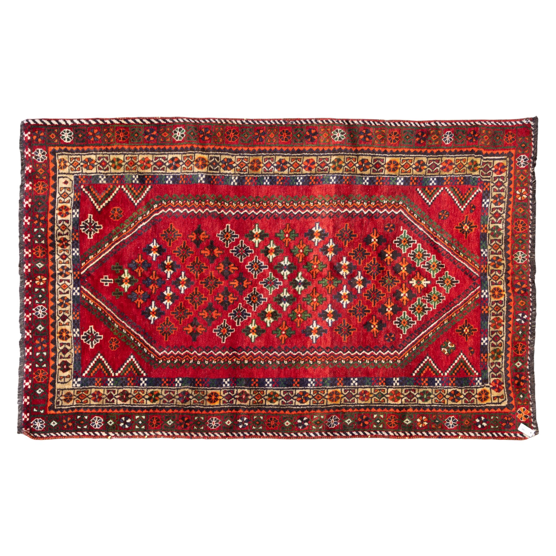 South West Persian Lori hand-knotted rug,  deep crimson field with a stepped lozenge medallion enclosing stylised floral motifs within multiple geometric borders of indigo, ivory, and green, with fringe ends 