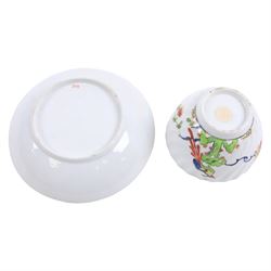 Chamberlain's Worcester teabowl and saucer, each of wrythen form decorated in the Sir Joshua Reynolds pattern, circa 1800, with long tailed Ho Ho bird perched upon green rockwork and surrounded by flowering vines, the saucer with iron red pattern number 203 beneath, teabowl H6cm D8.5cm, saucer D14cm