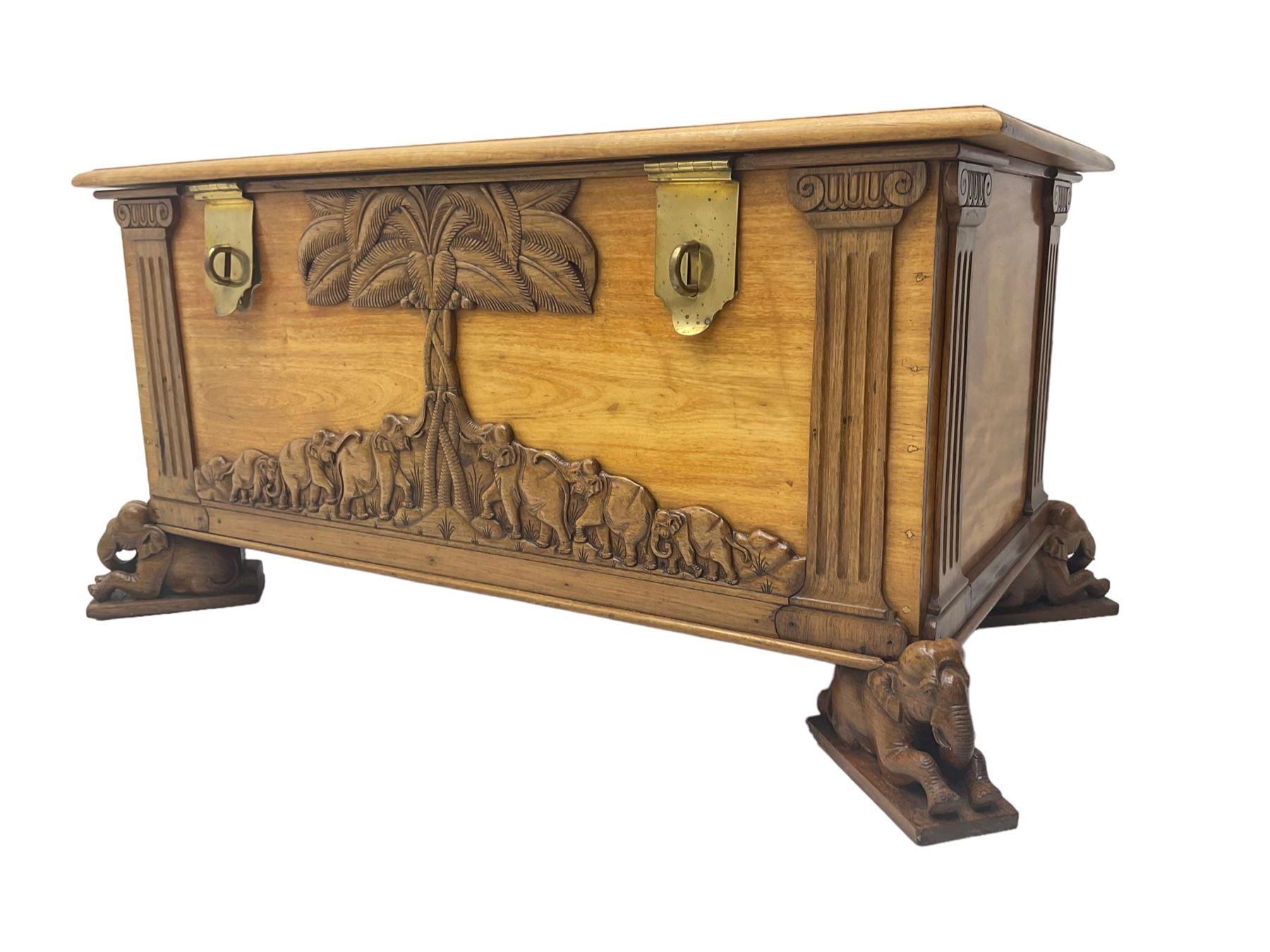 India camphor wood blanket box, moulded hinged lid, decorated with carved elephants and trees, on elephant carved feet