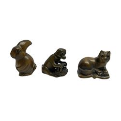 Three netsuke, modelled as a rabbit, dog with a basket and cat sat upon an open book