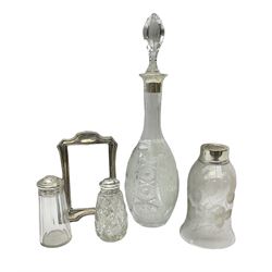 Clear glass decanter of slender oviform with silver collar stamped MN & WB 925, Mappin & Webb, together with an early 20th century silver photo frame hallmarked G & C Ltd of Birmingham, two clear glass shakers with pierced silver tops and silver collared glass storm lampshade with etched decoration, tallest H37.5cm
