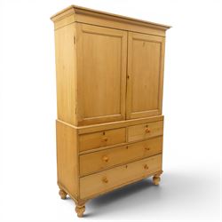 Victorian stripped pine housekeepers cupboard, projecting cornice over two panelled cupboard doors enclosing two shelves, the base fitted with two short over two long graduating drawers, lower moulded edge over turned feet