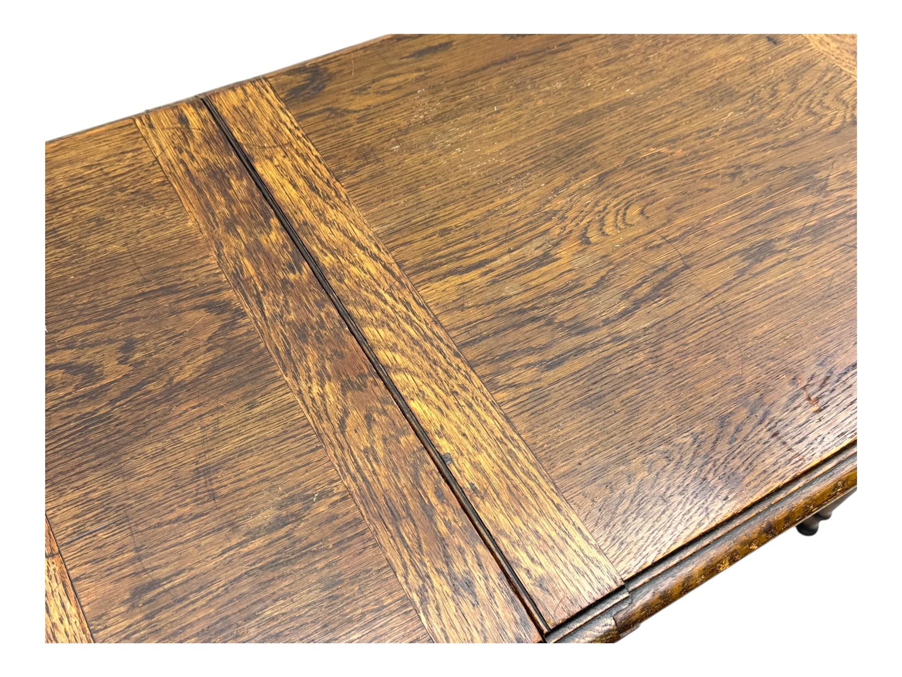 Edwardian oak metamorphic 'Britisher Writing Table', rectangular hinged top revealing correspondence compartments and hinged writing surface with underside storage, flanked by twin hinged compartments with dividers, on turned supports