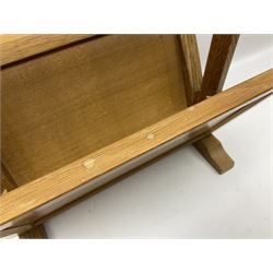 Mouseman - oak magazine rack, the top rail pierced with handle and carved with mouse signature, octagonal supports with two panelled and splayed sides, on sledge feet, by the workshop of Robert Thompson, Kilburn 