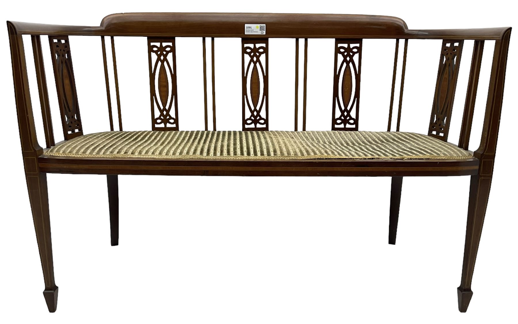 Edwardian inlaid mahogany two-seat salon sofa, curved back and arms inlaid with boxwood stringing, vertical slat back with pierced splats inlaid with satinwood, upholstered seat, on square tapering front supports with spade feet 
