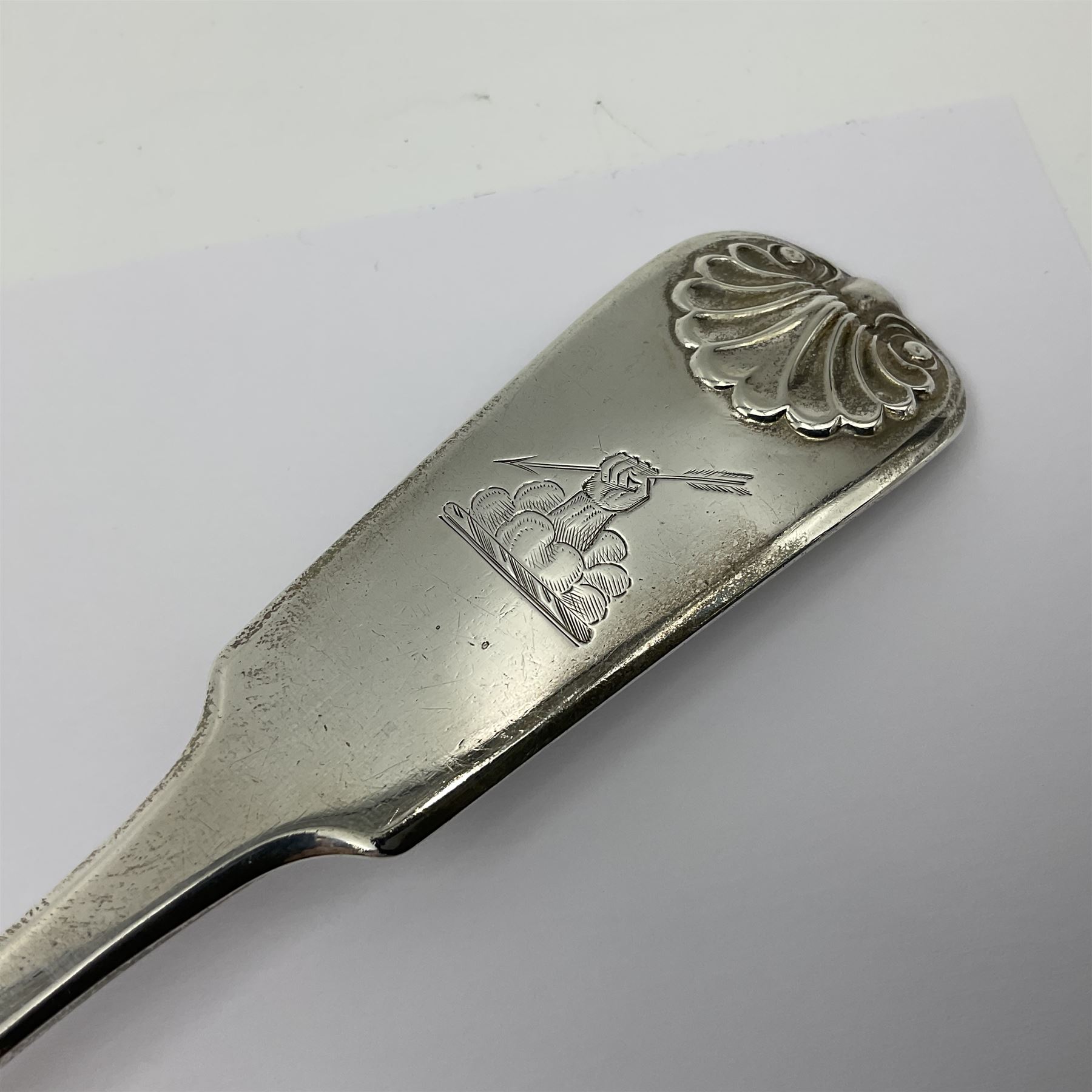 Victorian Newcastle silver Fiddle Shell pattern serving spoon, the terminal engraved with crest of a fist holding an arrow aloft, hallmarked Lister & Sons, Newcastle 1862, L31cm
