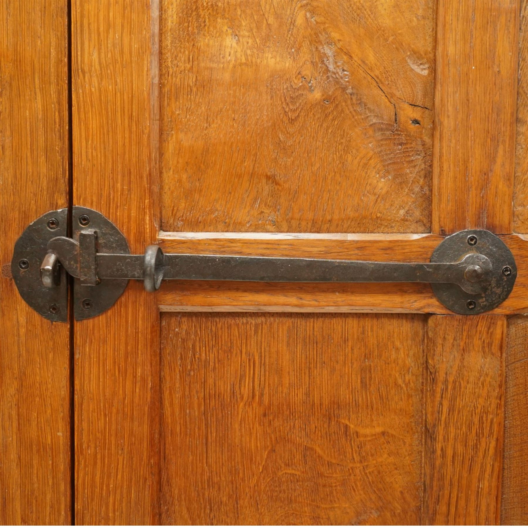 Mouseman - early-to-mid-20th century figured panelled and adzed double wardrobe of large proportions, the arcade carved cresting rail over two doors with adzed and figured oak panels, with wrought metal hinges and latch, relief carved mouse signature, the interior fitted with hanging rail, by the workshop of Robert Thompson, Kilburn