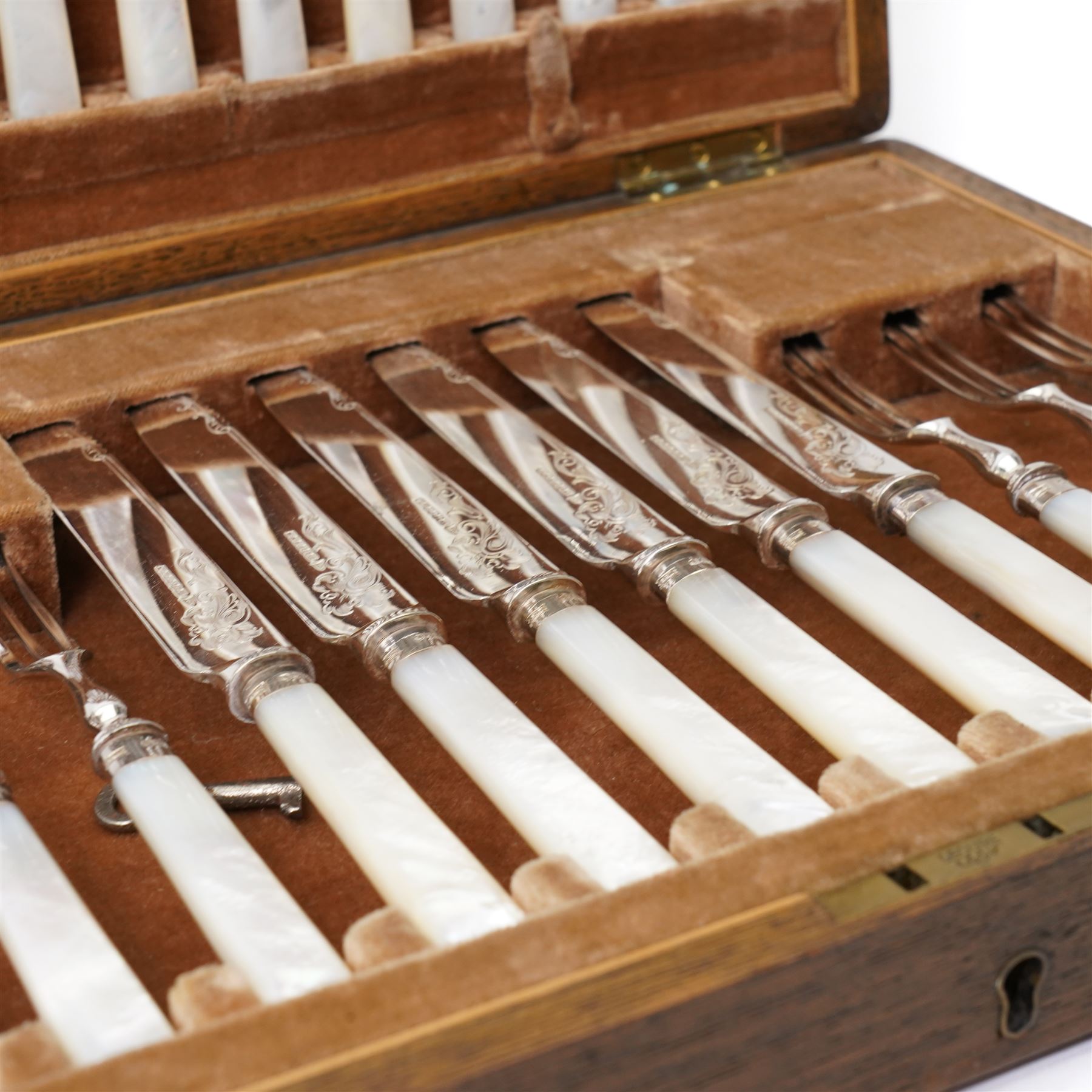 Set of twelve dessert knives and forks with engraved plated blades, silver collars and mother of pearl handles by Walker & Hall in oak box Sheffield 1927 and a set of twelve plated fish knives and forks with servers, boxed