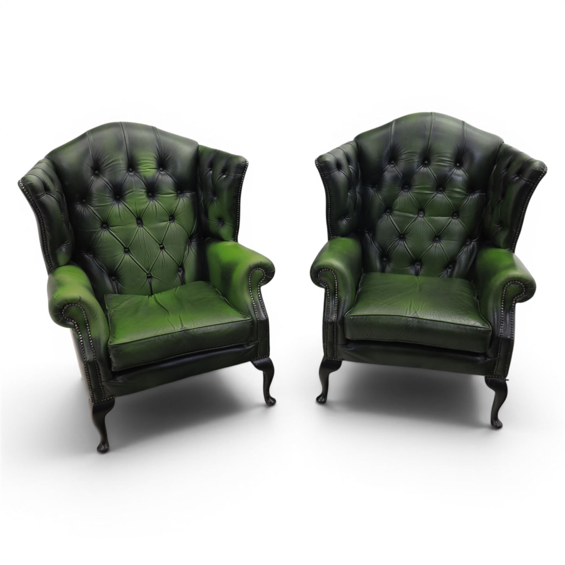 Thomas Lloyd - Pair of Queen Anne design wingback armchairs upholstered in buttoned green leather, button back and scrolled arms, raised on cabriole supports. 