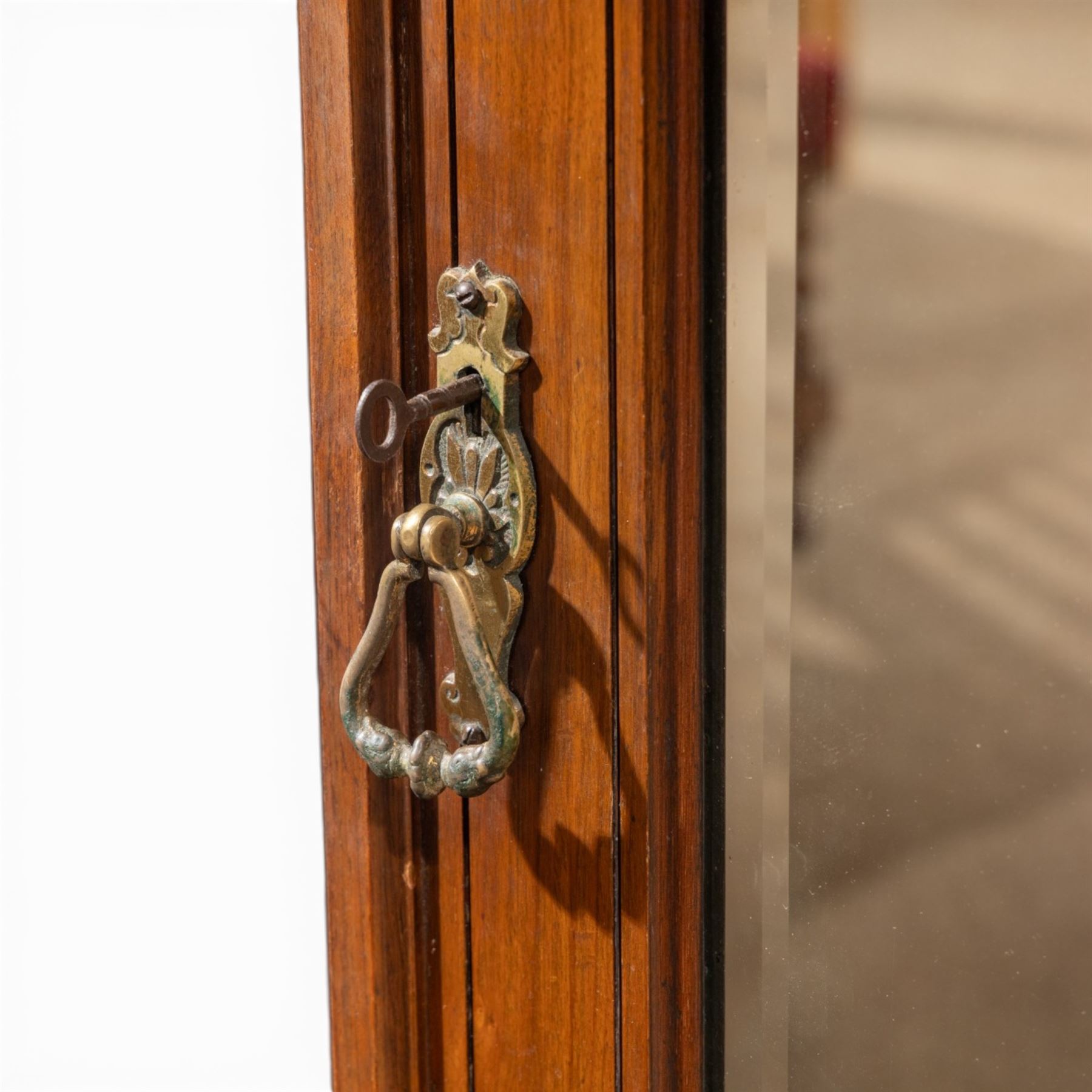 Edwardian figured walnut triple combination wardrobe, moulded cornice above a three part wardrobe, central section with figured walnut panelled doors, above two over three drawers, flanked by mirrored doors enclosing hanging hooks, raised on a plinth