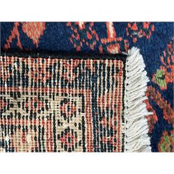 Persian Joshgan red ground rug, the medallion, field and spandrels decorated with clusters of Pitrak and tree of life motifs, the border with repeating design decorated with stylised plant motifs, within guard stripes