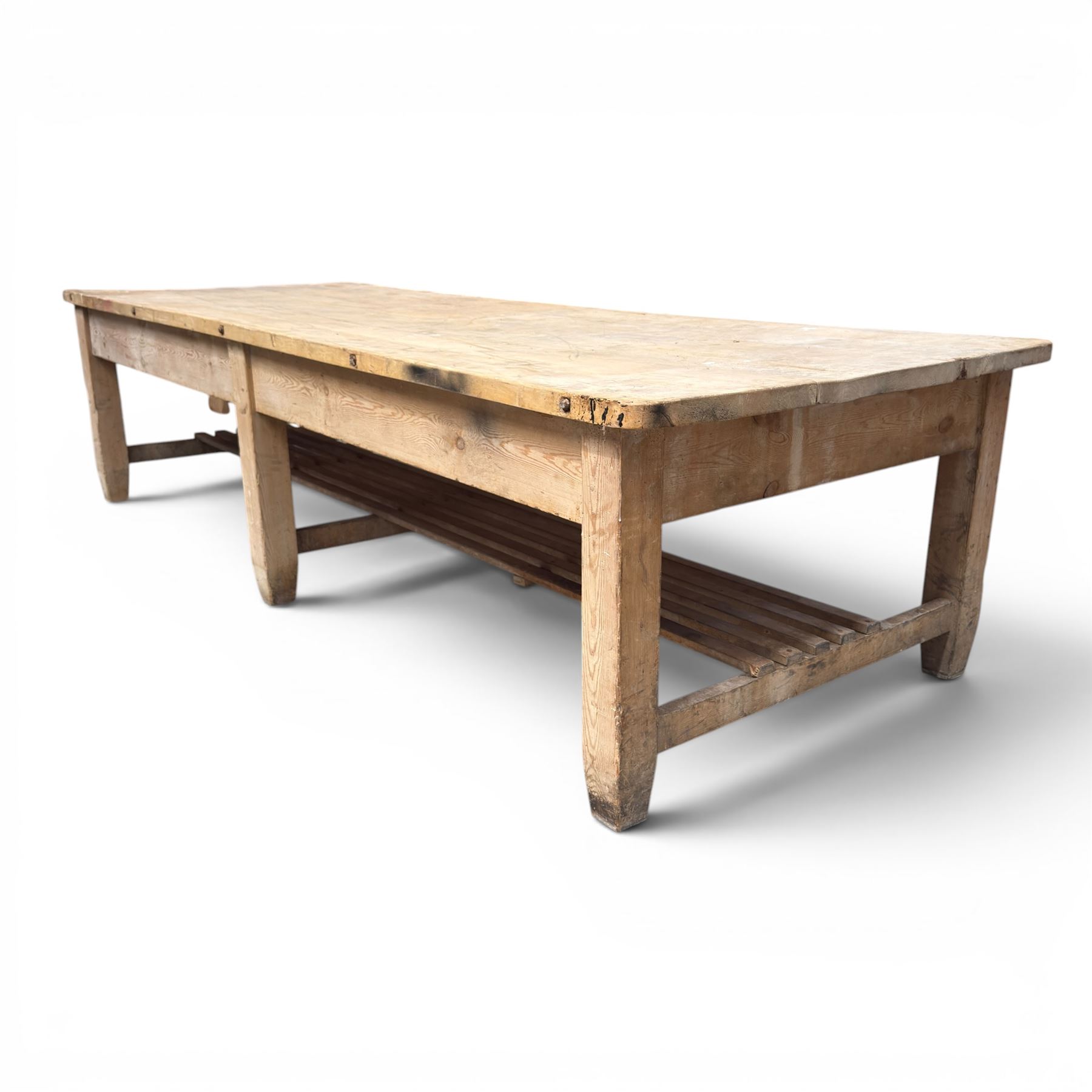 Large early/mid-20th century pine table or work bench, rectangular six plank top on eight tapering supports joined by slatted undertier