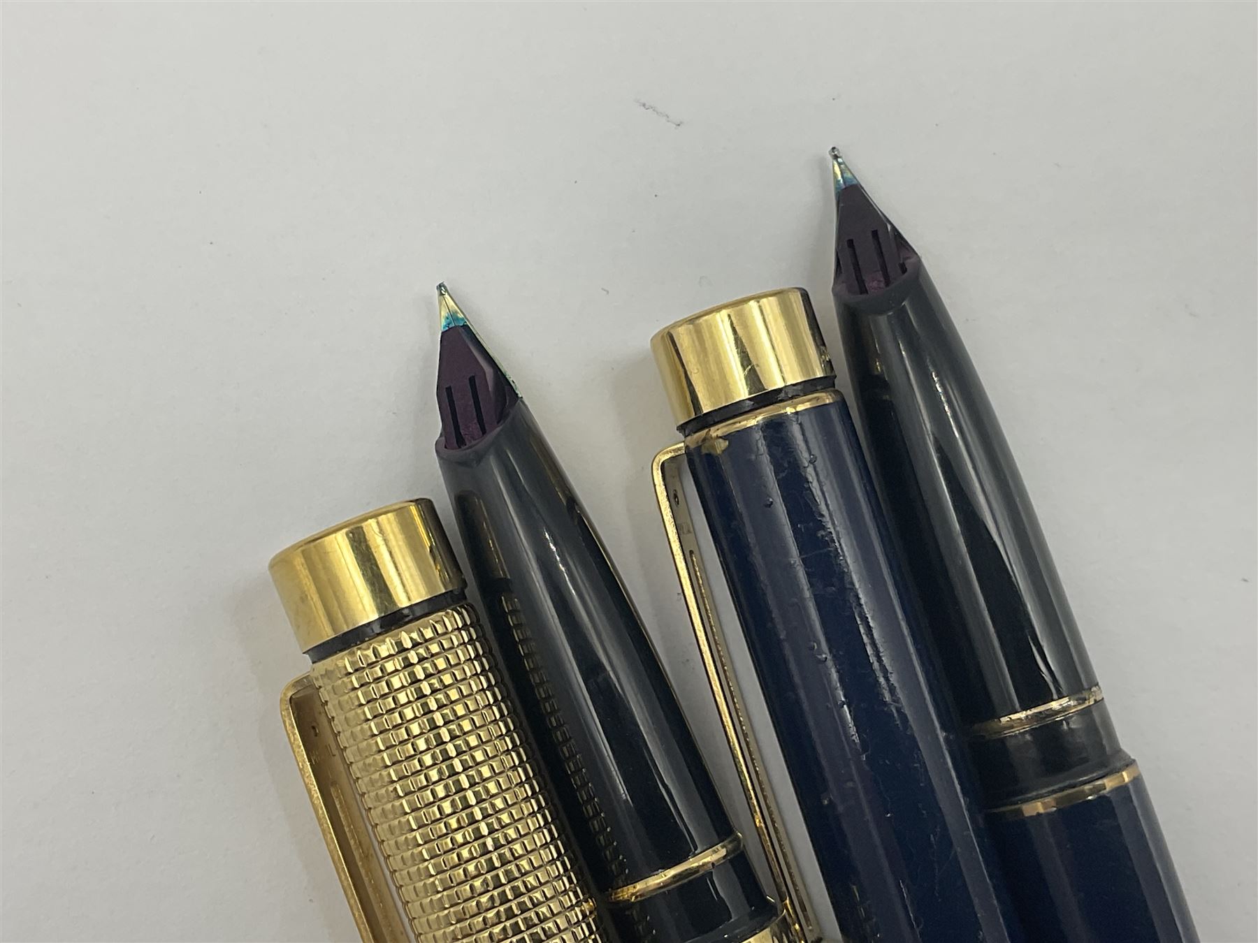 Sheaffer Targa 1011 Diamond Square fountain pen, the gold plated barrel with nib stamped 14K 585, together with another Sheaffer Targa fountain pen with blue barrel and gold nib stamped 14K 585 and matching ballpoint, and Sheaffer ballpoint pen with sterling silver barrel, largest L13.5cm (4)