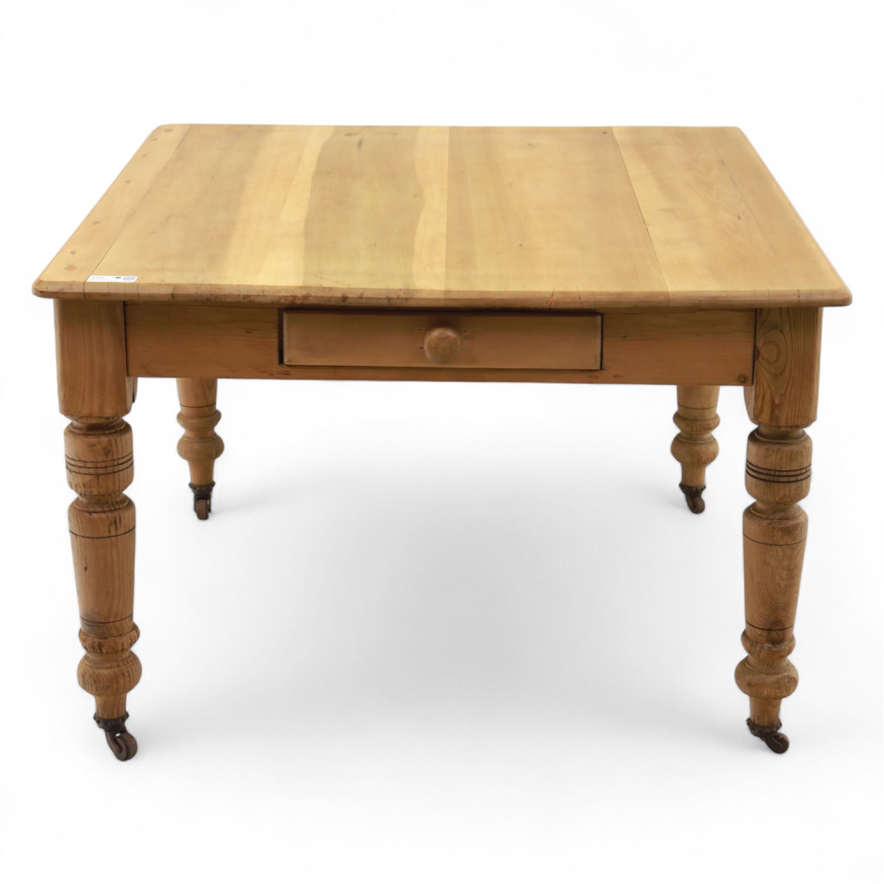 Contemporary pine kitchen table, rectangular top with moulded edge, fitted with single drawer, raised on turned supports with ceramic castors
