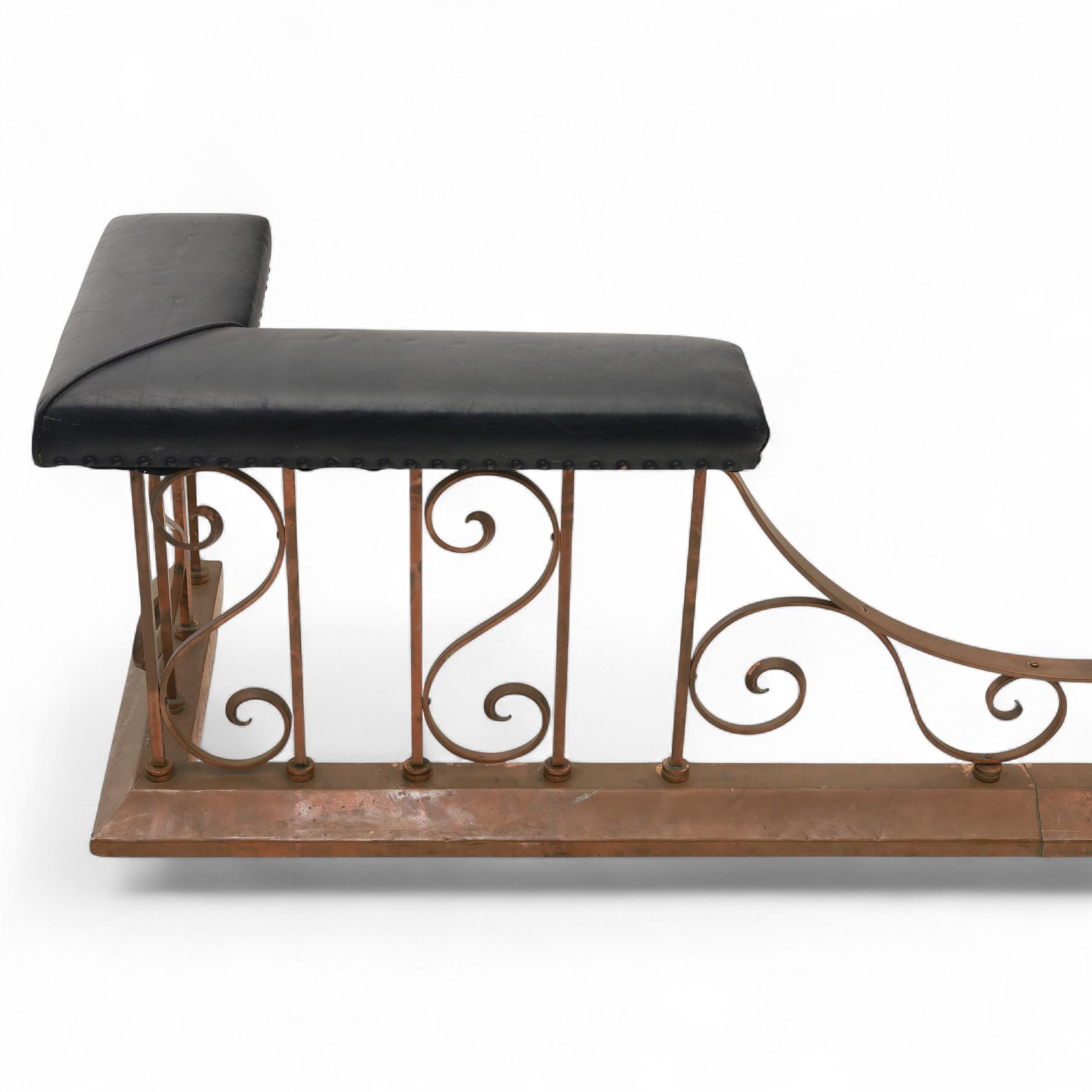 Early 20th-century Arts & Crafts copper club fender, of long serpentine form, scrolling uprights and a shaped centre support, the top rail fitted with four upholstered padded seat sections, raised on a stepped plinth base, inner dimensions 192x43cm 
