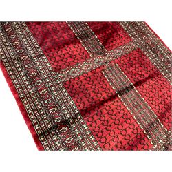 Tekke Ensi crimson ground rug, the quartered field decorated with candelabra motifs, multi-guarded border with repeating geometric hexagonal lozenges in blue and ivory