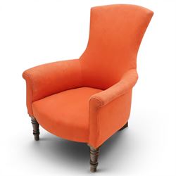 Victorian coral red upholstered armchair, the swept high back above padded arms with rolled fronts, on short turned ebonised front supports with castors