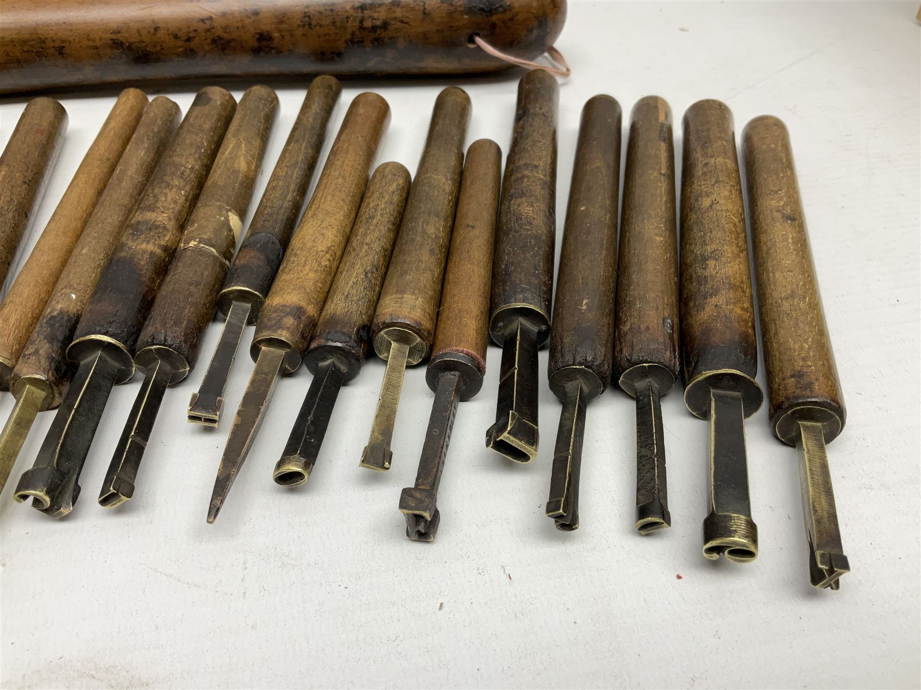 Thirty-one bookbinder's brass number and letter stamps, predominantly with beech handles, together with a bookbinder' decorative fillet roll, with brass triple line wheel stamped E. Menuel London, with wood handle, and two ink blotters