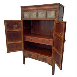 Late 19th century Chinese Qing dynasty red and black lacquered wood cabinet,  Fujianese province, upper cupboard enclosed by two doors with relief carved and gilt panels depicting figures behind glass, the large cupboard enclosed by two panelled doors carved with trailing foliate branches and birds, inscribed with Chinese characters, to the left ‘The red mountains are in the shape of Phoenixes and appear auspicious’ and to the right, ‘Wealth and honour are given by flowers and I hear the sound of the phoenix', fitted with two drawers, on square supports with carved brackets 